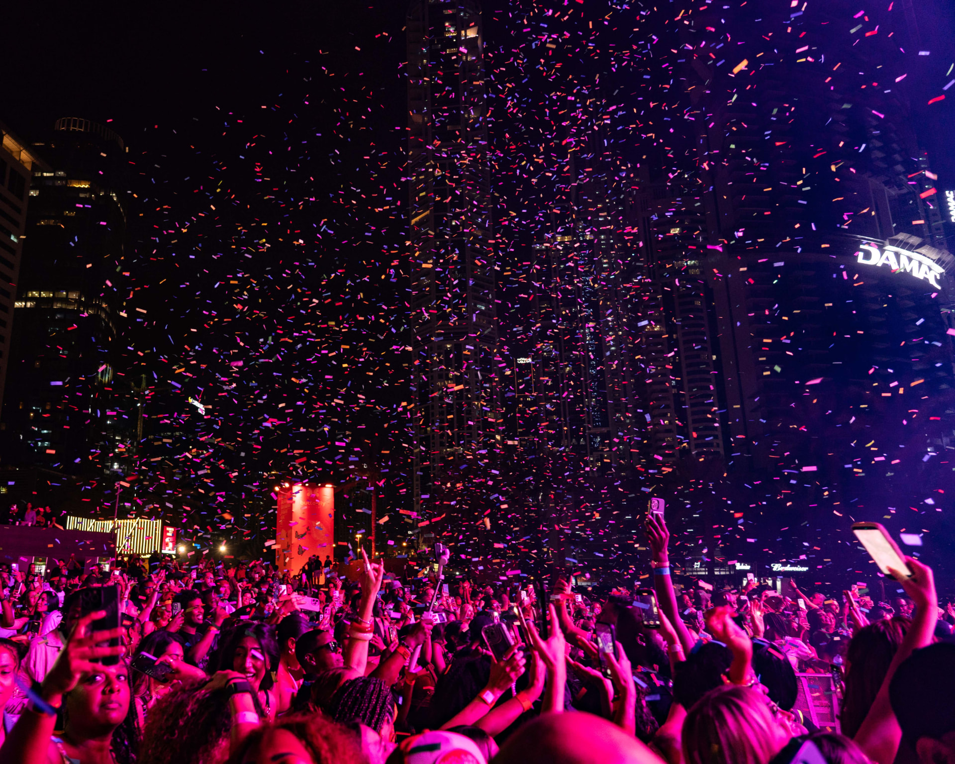 A packed outdoor Spot Network event beneath city lights and confetti
